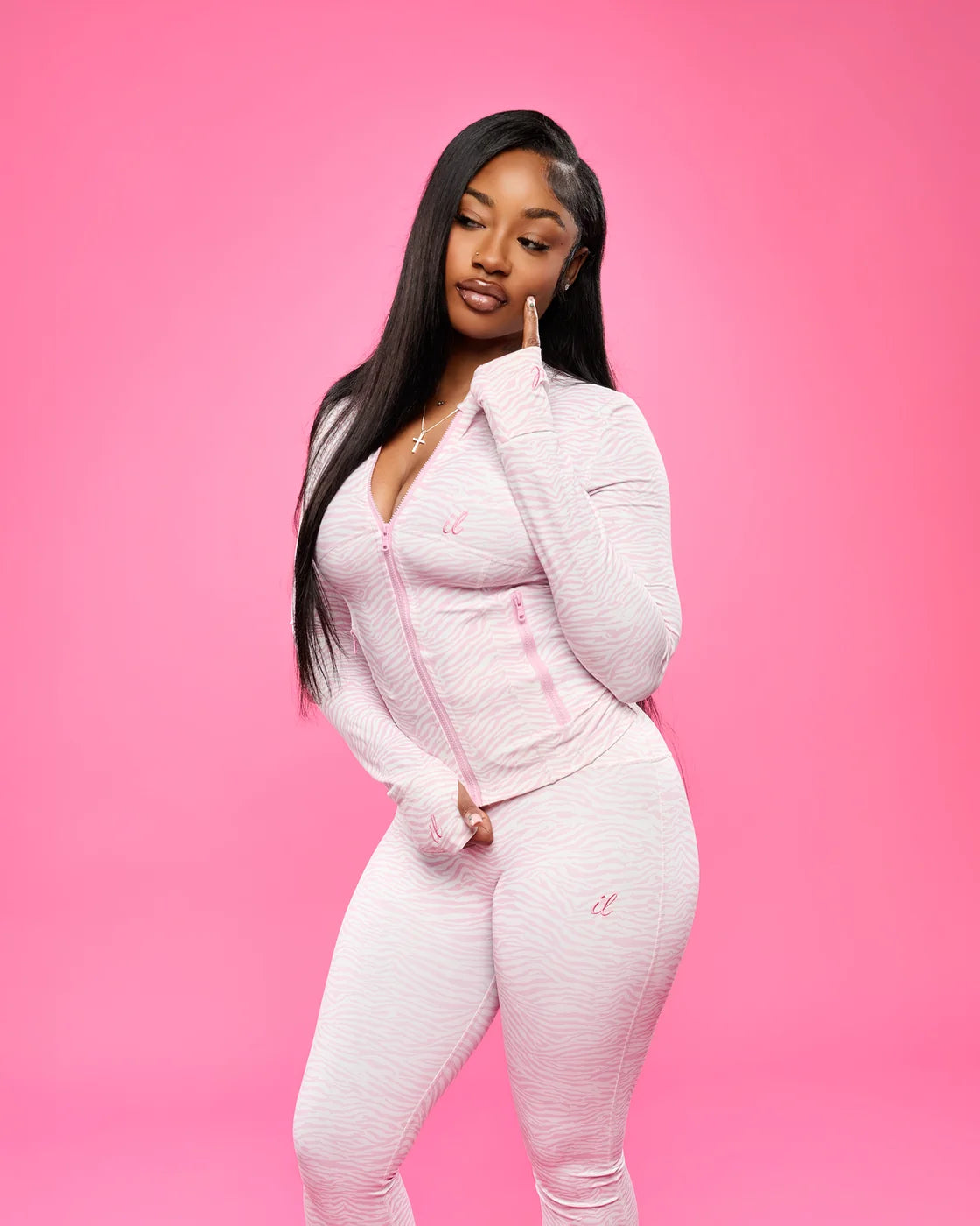 An ILUREIA girl in the pink zebra set on a pink backdrop, the full look